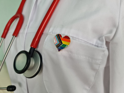 Silhouette of doctor in white coat with stethoscope and LGBT badge on pocket concept