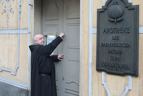 Das Bild zeigt Frater Matthias vor der Apotheke in Graz.