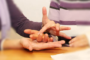 Buchstaben werden in die Hand des Gegenübers getippt