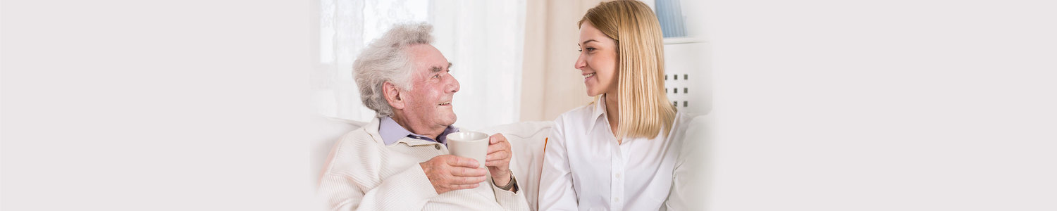 Das Bild zeigt einen Senior und eine Pflegerin