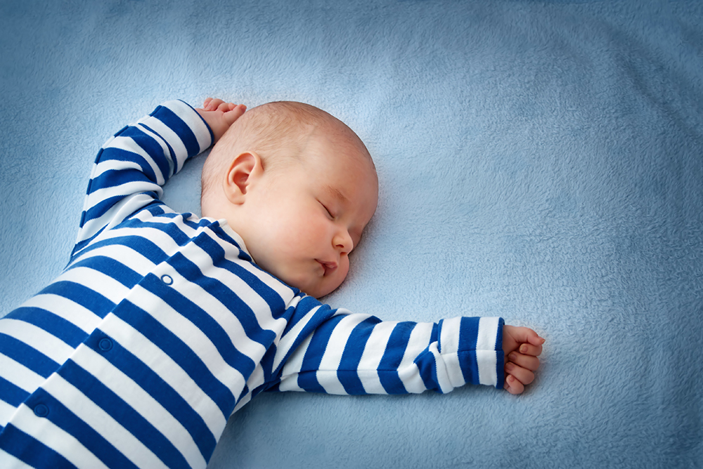little boy sleeping on soft blue blanket