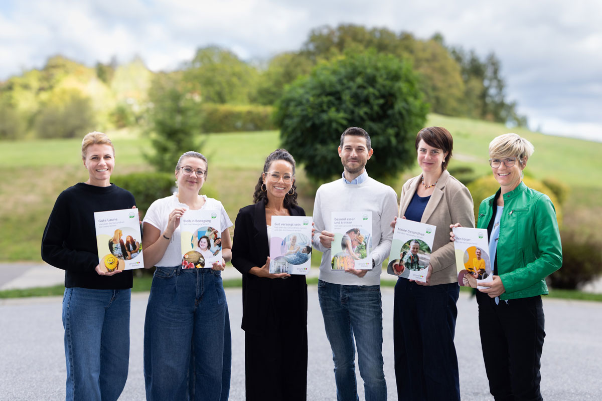 Die Projektpartner:innen präsentieren die begleitenden Broschüren zum Kurs 'gesund bleiben'.