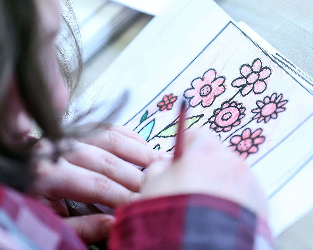 Das Foto zeigt eine Person die Blumen zeichnet