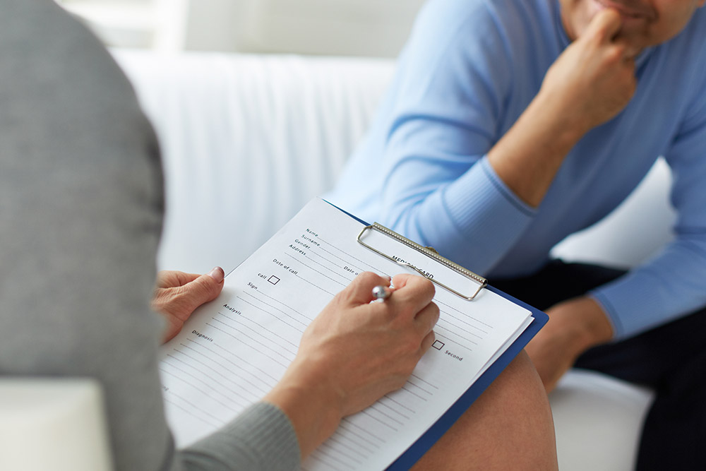 Female psychologist consulting mature man during psychological therapy session