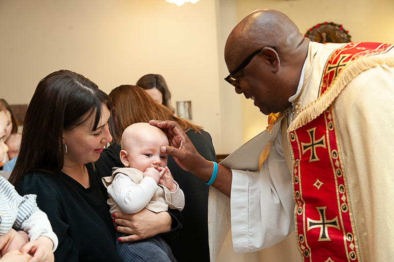 Mutter mit Kind und Pfarrer Joseph Tombert 