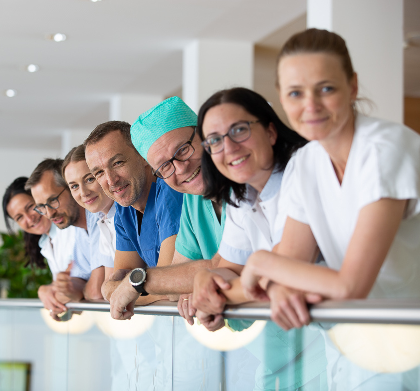 Mehrere Mitarbeiter lächeln in die Kamera