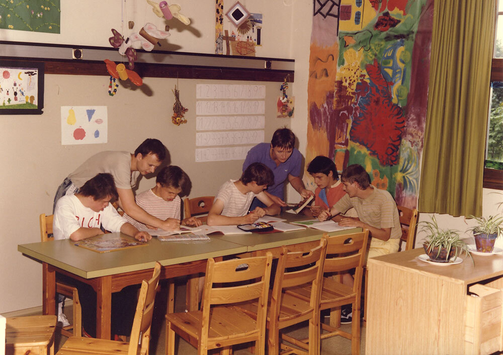 Das Bild zeigt Bewohner*innen und Betreuer*innen in der Sonderschule im Jahre 1985