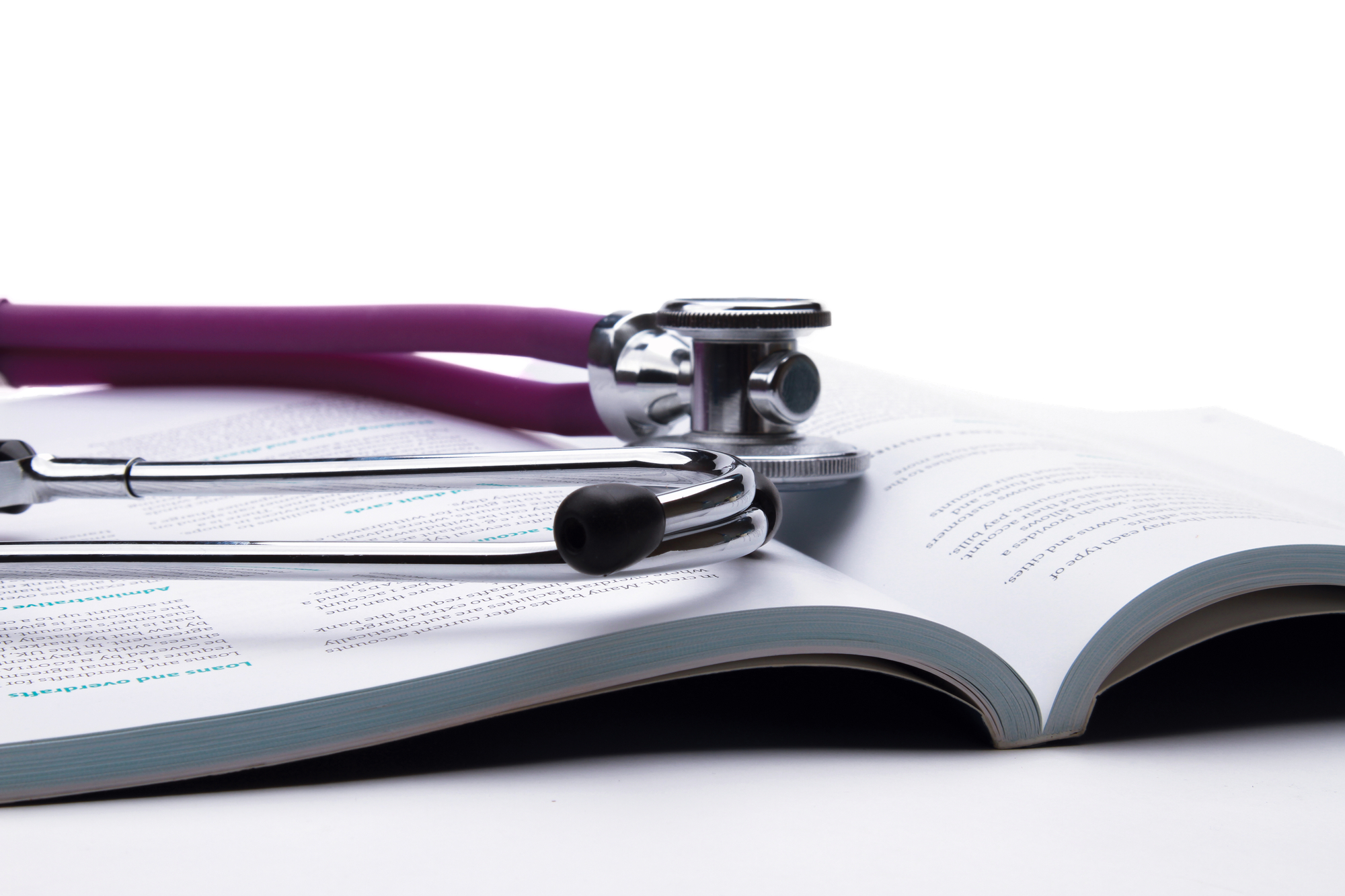 A stethoscope is lying on an open book
