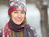 Das Bild zeigt eine lachende Frau im Schnee.