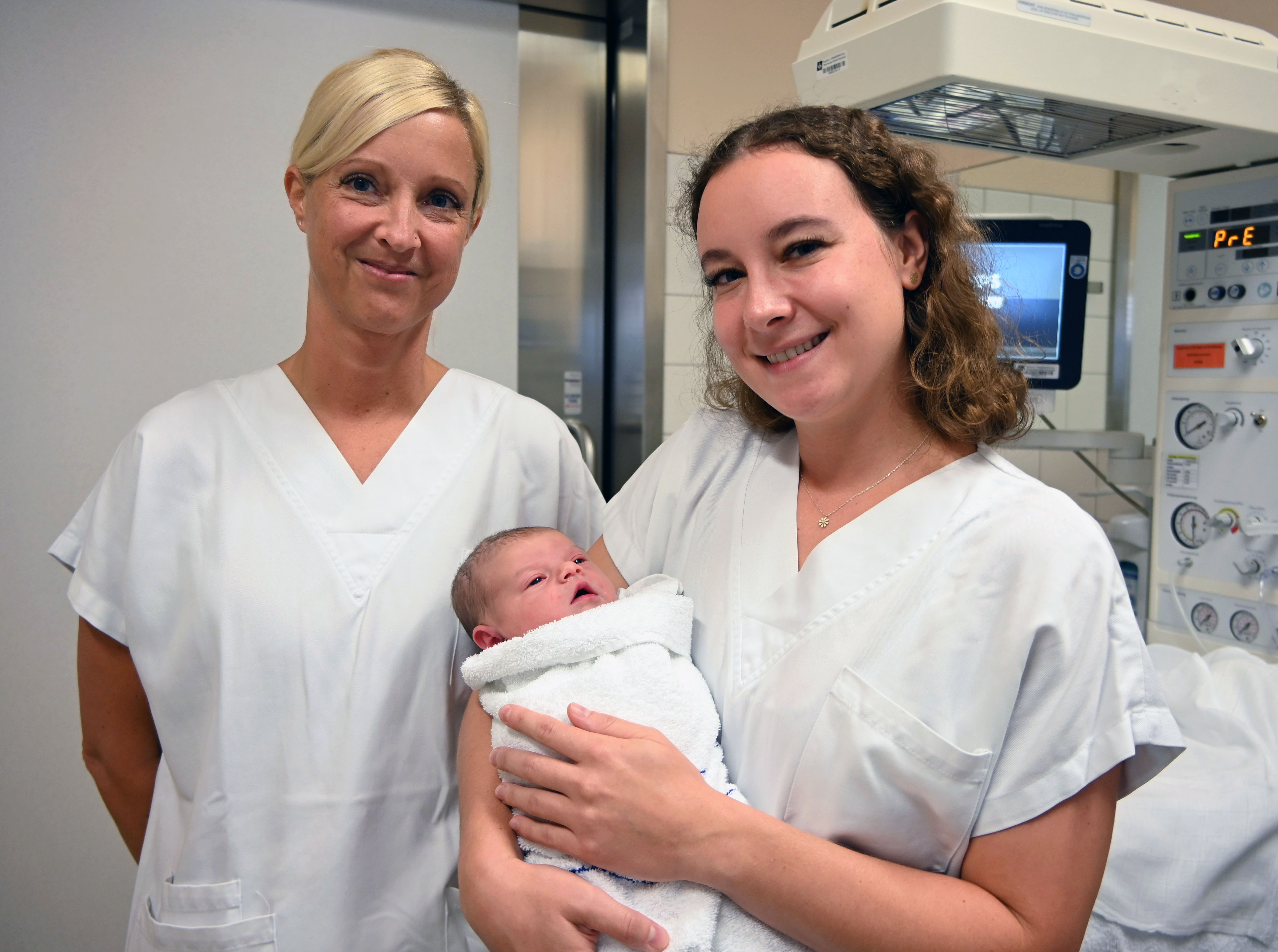 v.l.n.r DGKP Nicole Dörfler und Hebamme Tanja Gruber, BSc mit dem 500. Baby im Arm 