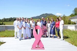 Das Team des Brustzentrums Kärnten mit den Fachgutachtern Oberärztin Dr. Kristina Schönau und  DI Rainer Hartmann vor der Pink Ribbon-Schleife – dem internationalen Symbol für Brustkrebsaufklärung. Die Re-Zertifizierung des Brustzentrums bestätigt di