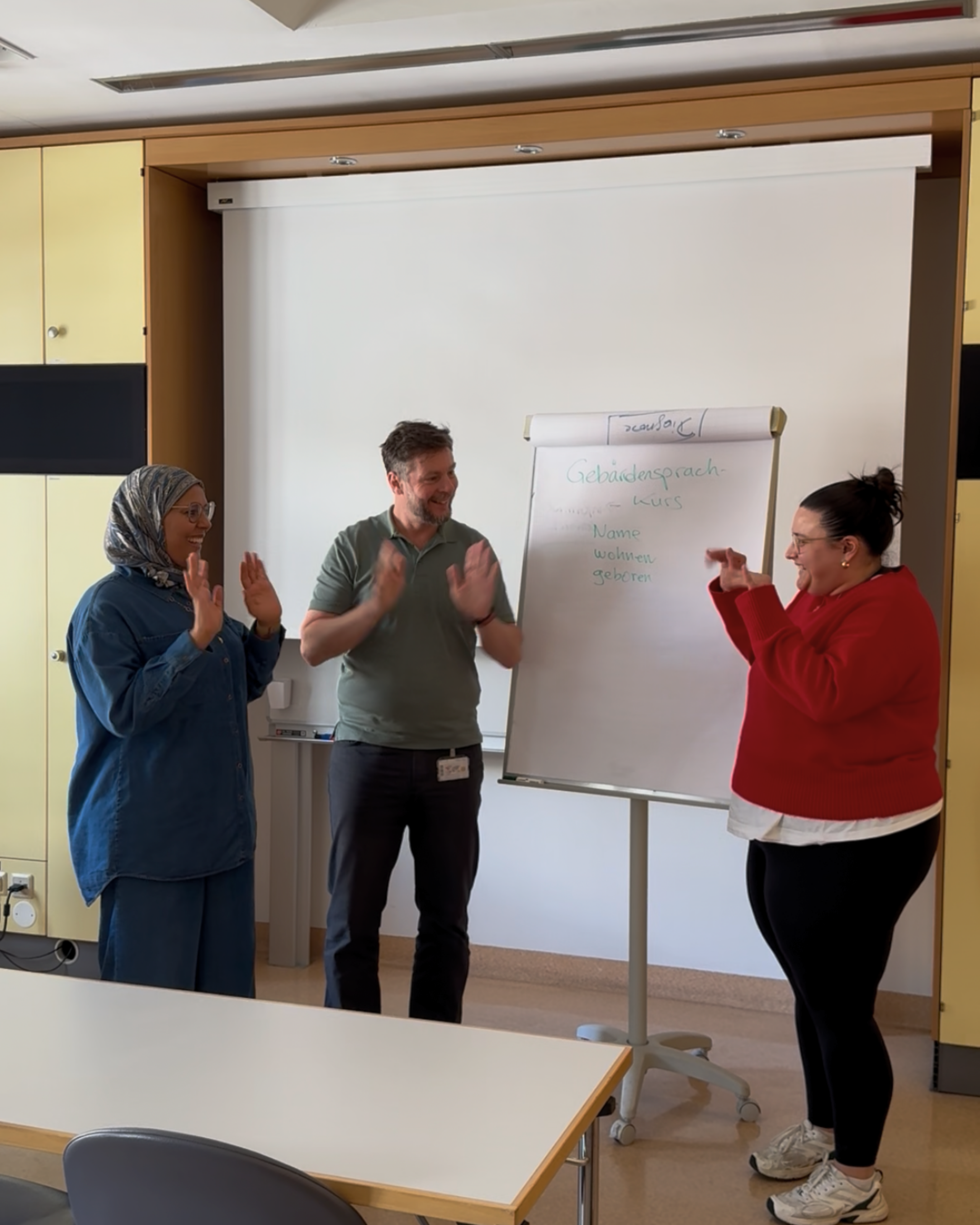 Drei Personen, die miteinander gebärden