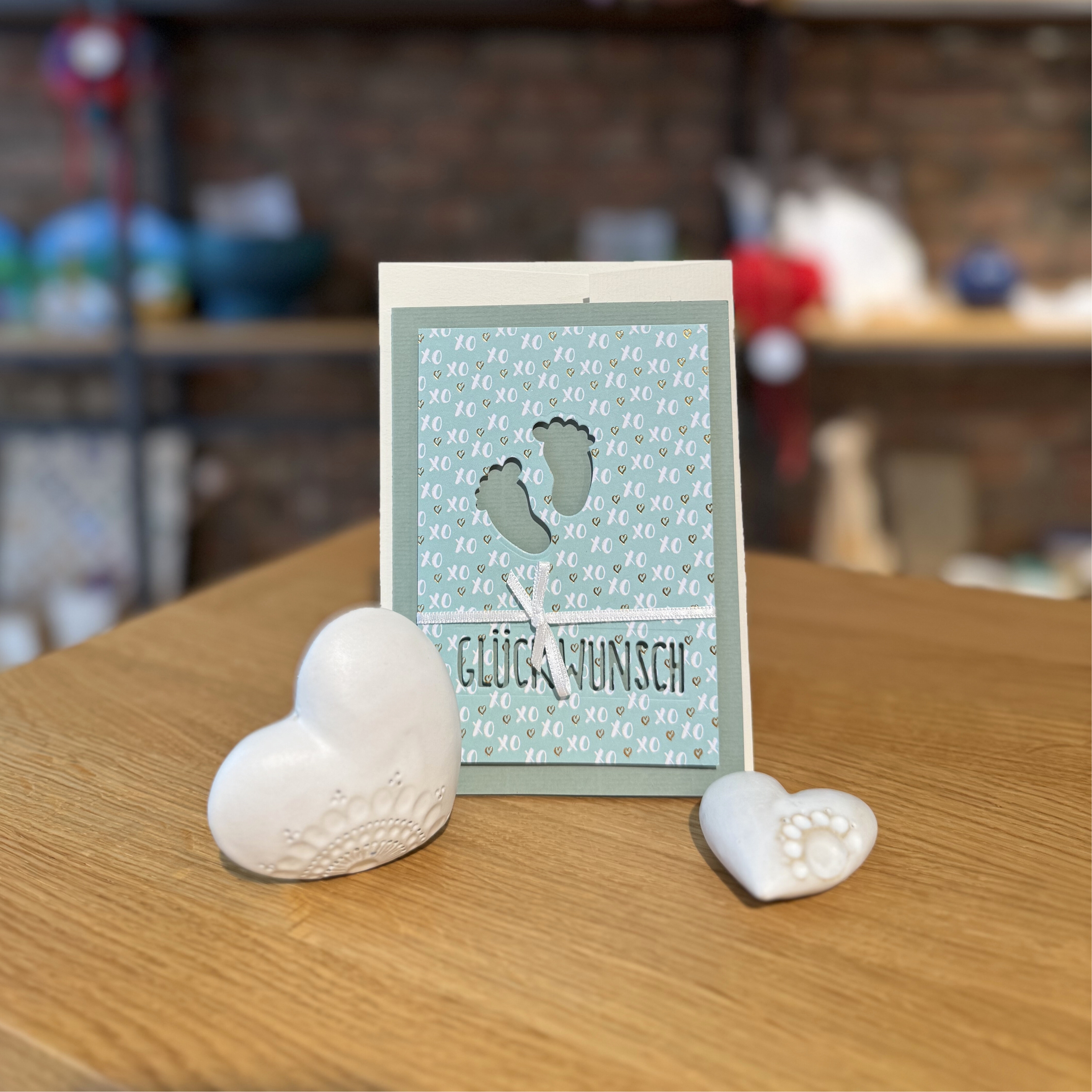 handgefertigte Karte in Blau mit Babyfüßen drauf und 'Glückwunsch' als Text