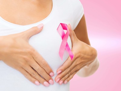 healthcare and medicine concept - woman in blank t-shirt with pink breast cancer awareness ribbon checking breast