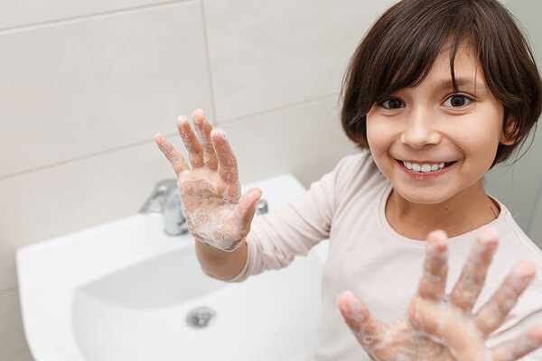 Das Bild zeigt ein Mädchen beim Händewaschen.