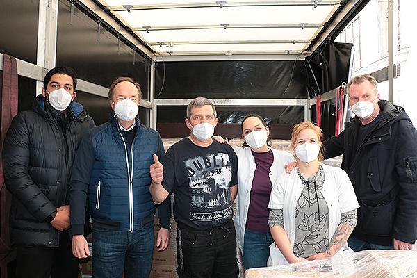 Das Bild zeigt Mitarbeitende mit Hilfslieferungen für die Ukraine.