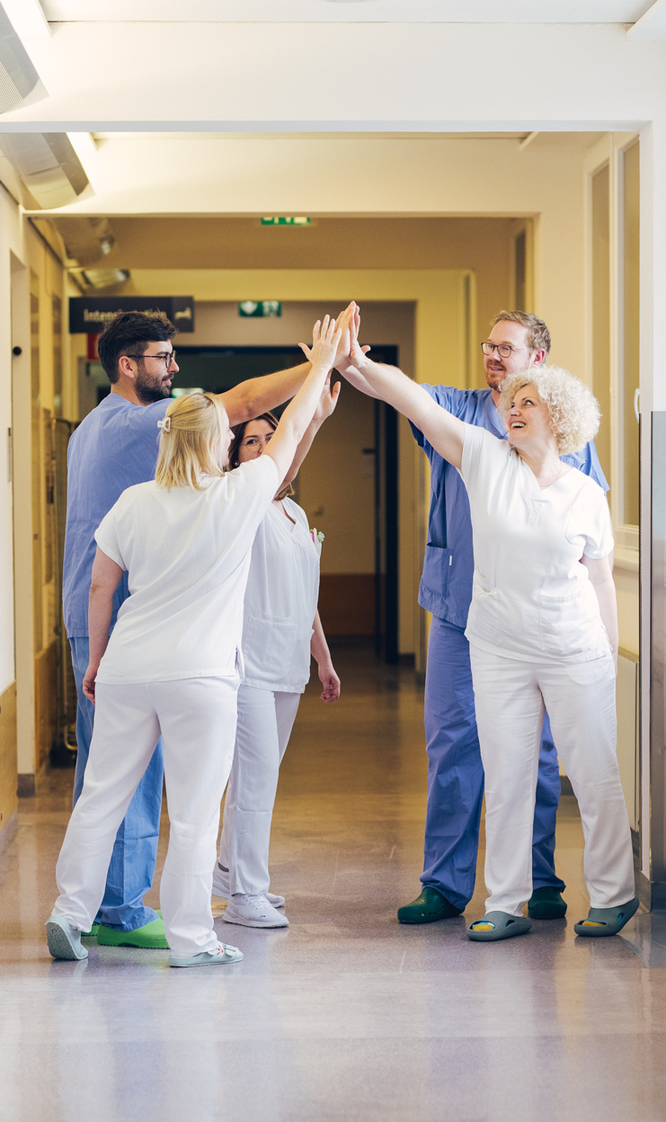 vier kolleginnen pflege handshake
