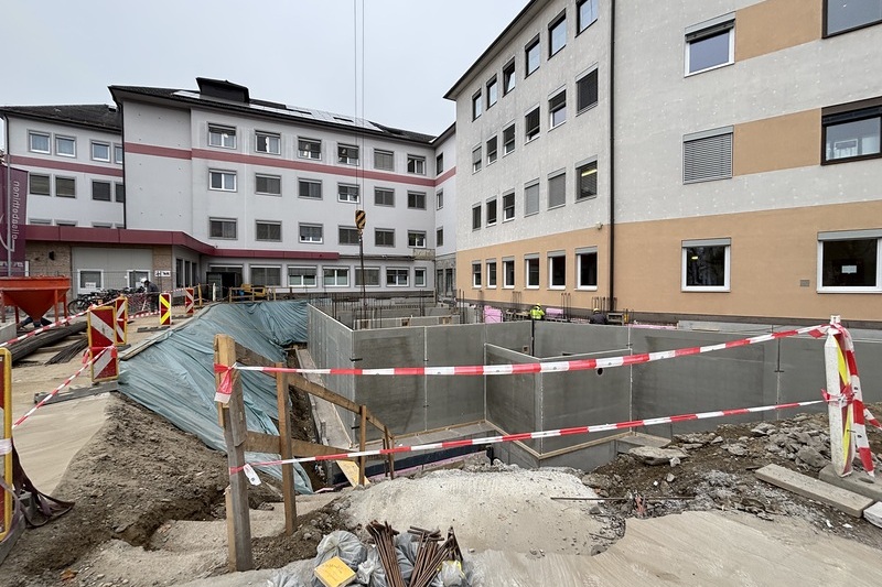 Kellerwände aufstellen / EKH Der Bau des Kellers nimmt Gestalt an: Die ersten Wände werden errichtet, wobei der Einsatz von Fertigteilelementen sowohl die Lärmbelästigung reduziert als auch den Bauablauf deutlich beschleunigt