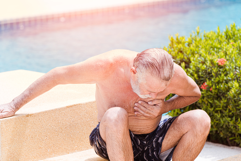 Elder pain suffer from heart attack at swimming pool in summer hot sunny day