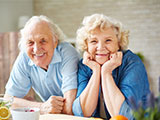 Das Bild zeigt eine zufrieden aussehende ältere Dame und einen älteren Herren.