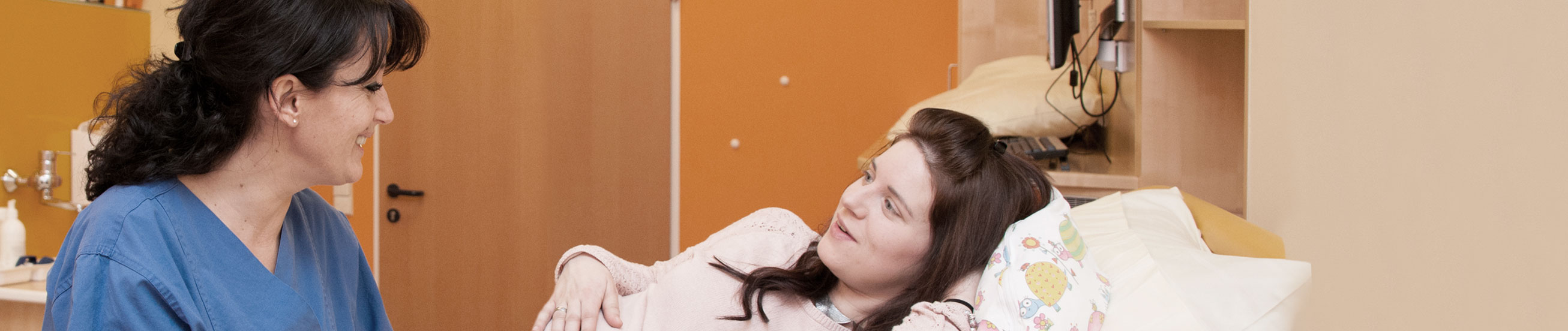 Das Bild zeigt eine Hebamme mit einer werdenden Mutter.