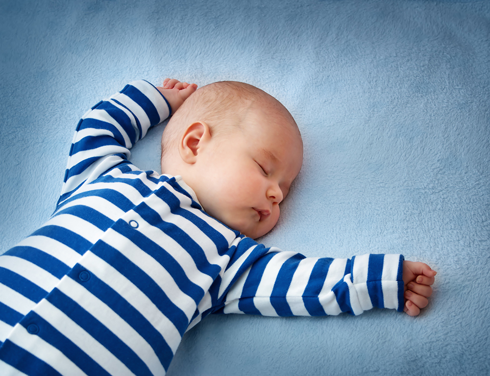 little boy sleeping on soft blue blanket