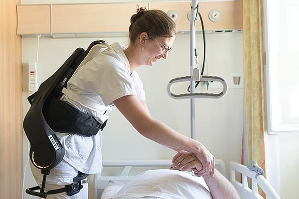 Das Bild zeigt eine Pflegeperson mit einem Exoskelett.
