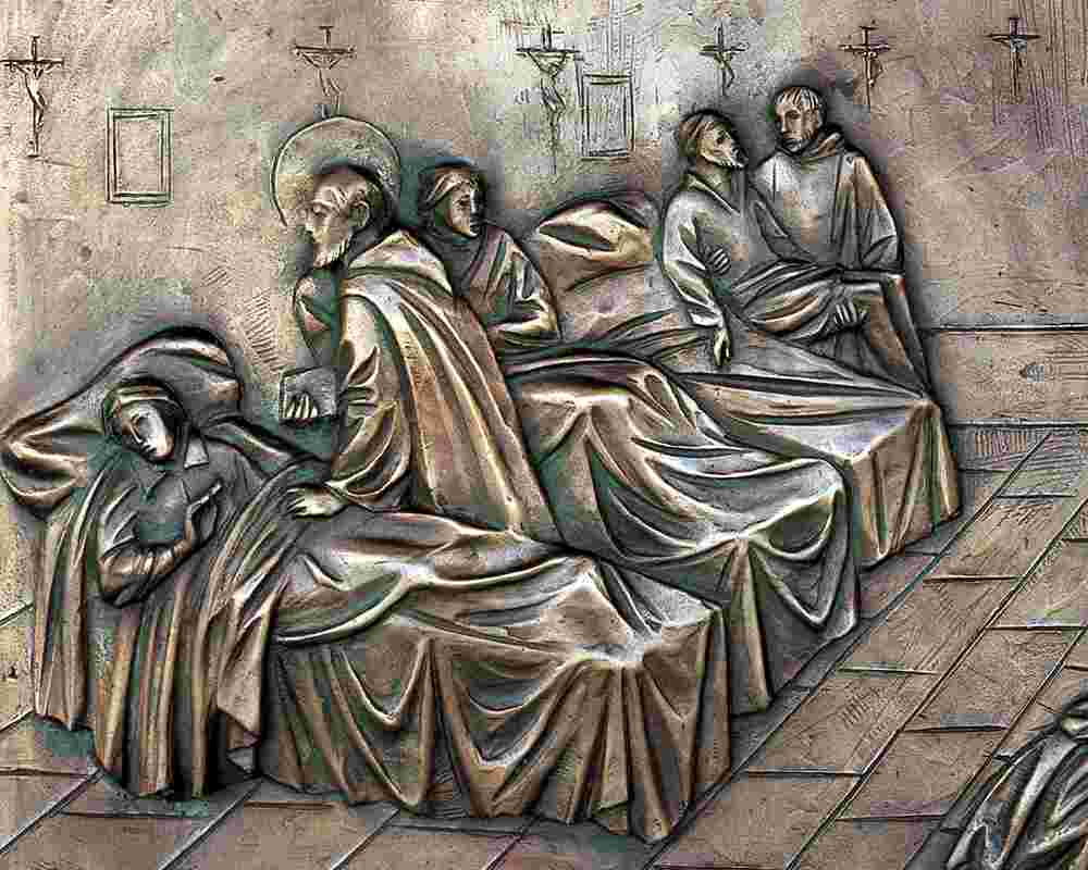 Das Bild zeigt eine Bronzeplastik aus Palermo, die Johannes von Gott und Helfer bei der Pflege Kranker darstellt.