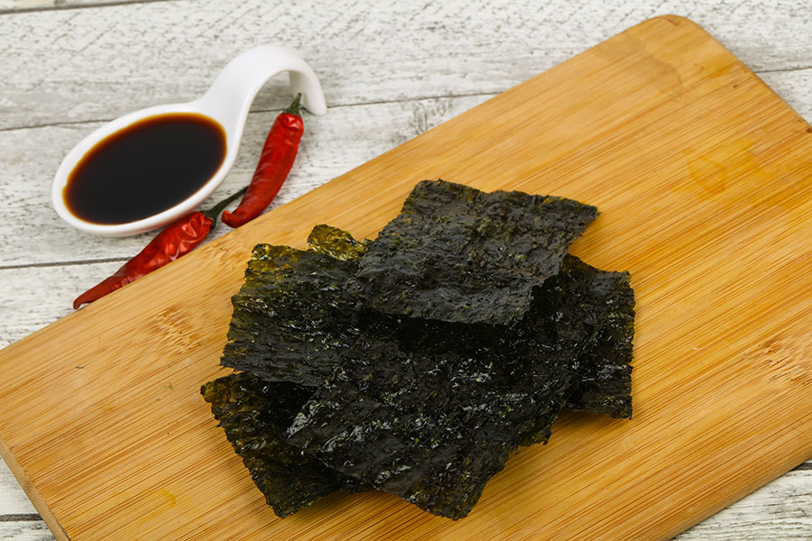 Das Bild zeigt eine Schneidebrett mit getrockneten Nori-Algen.