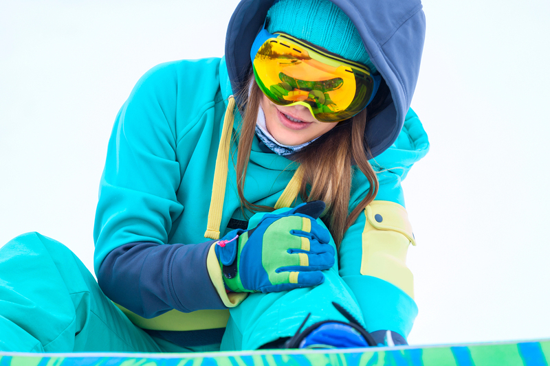 Frau mit Knieverletzung beim Snowboarden