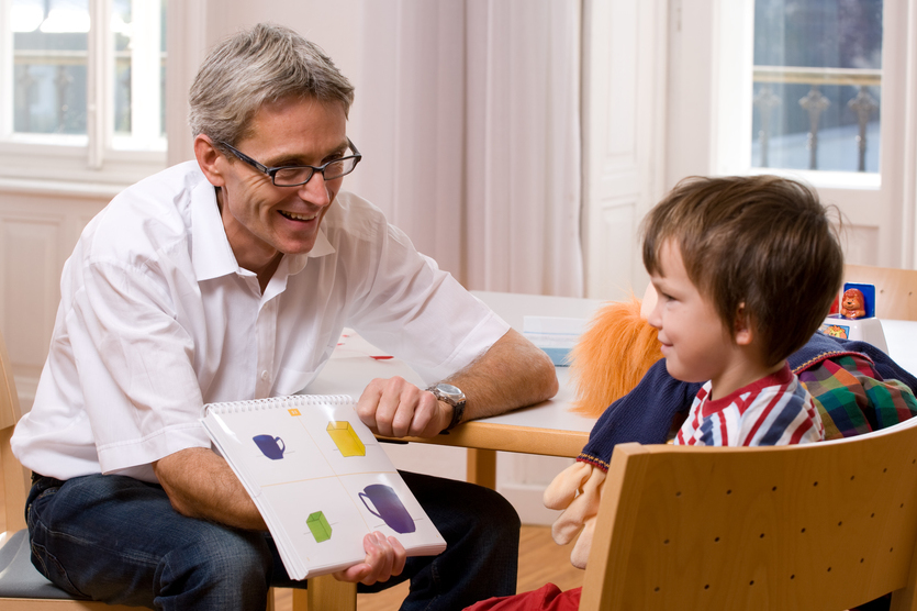Sprech- und Sprachstörung NLA / Barmherzige Brüder Linz Das Bild zeigt ein Patientenkind mit seinem Betreuer.