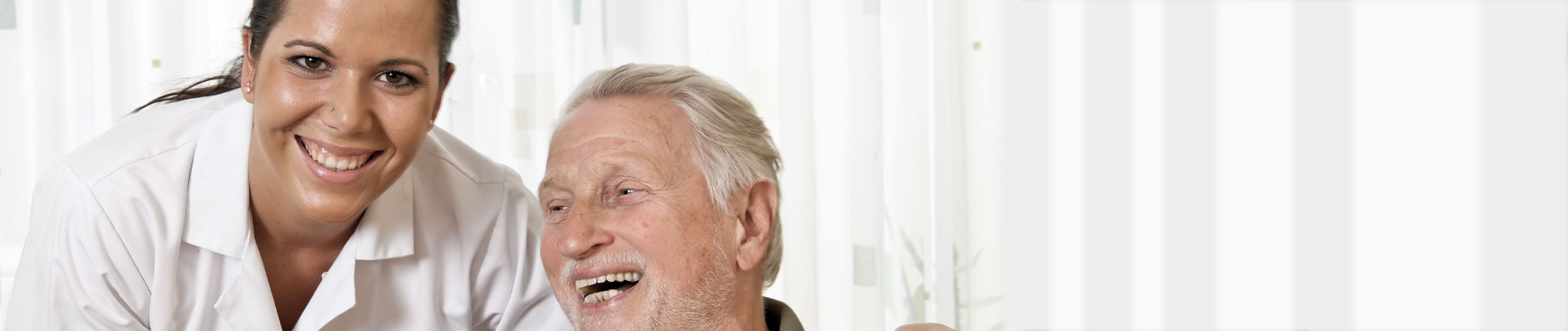 Das Bild zeigt eine DGKP mit einem Bewohner im Seniorenheim.