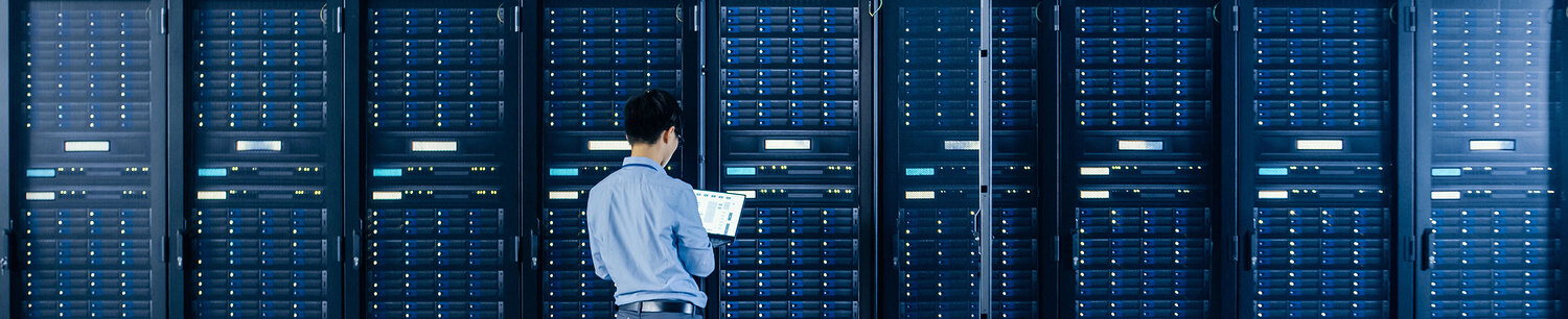 Ein Mann mit Laptop in einen Serverrraum.