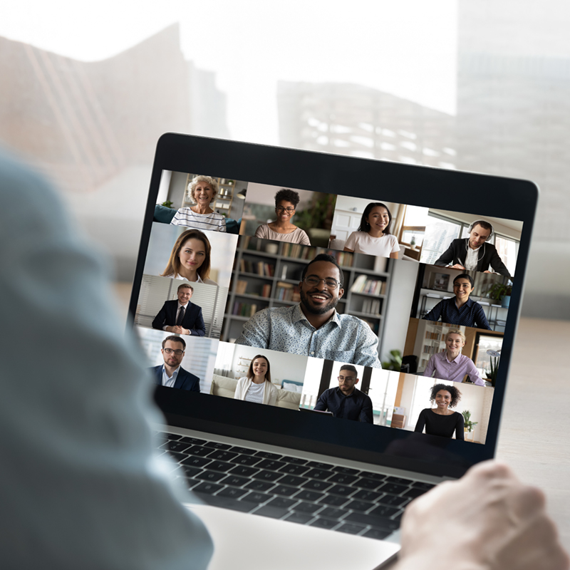 Back view of male employee have online video call on laptop with diverse multiethnic colleagues, man worker involved in webcam conference or virtual event on computer with multiracial businesspeople