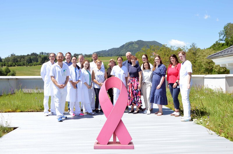Team Brustzentrum Kärnten / Barmherzige Brüder Das Team des Brustzentrums Kärnten mit den Fachgutachtern Oberärztin Dr. Kristina Schönau und DI Rainer Hartmann vor der Pink Ribbon-Schleife – dem internationalen Symbol für Brustkrebsaufklärung. Die Re-Zertifizierung des Brustzentrums bestätigt di