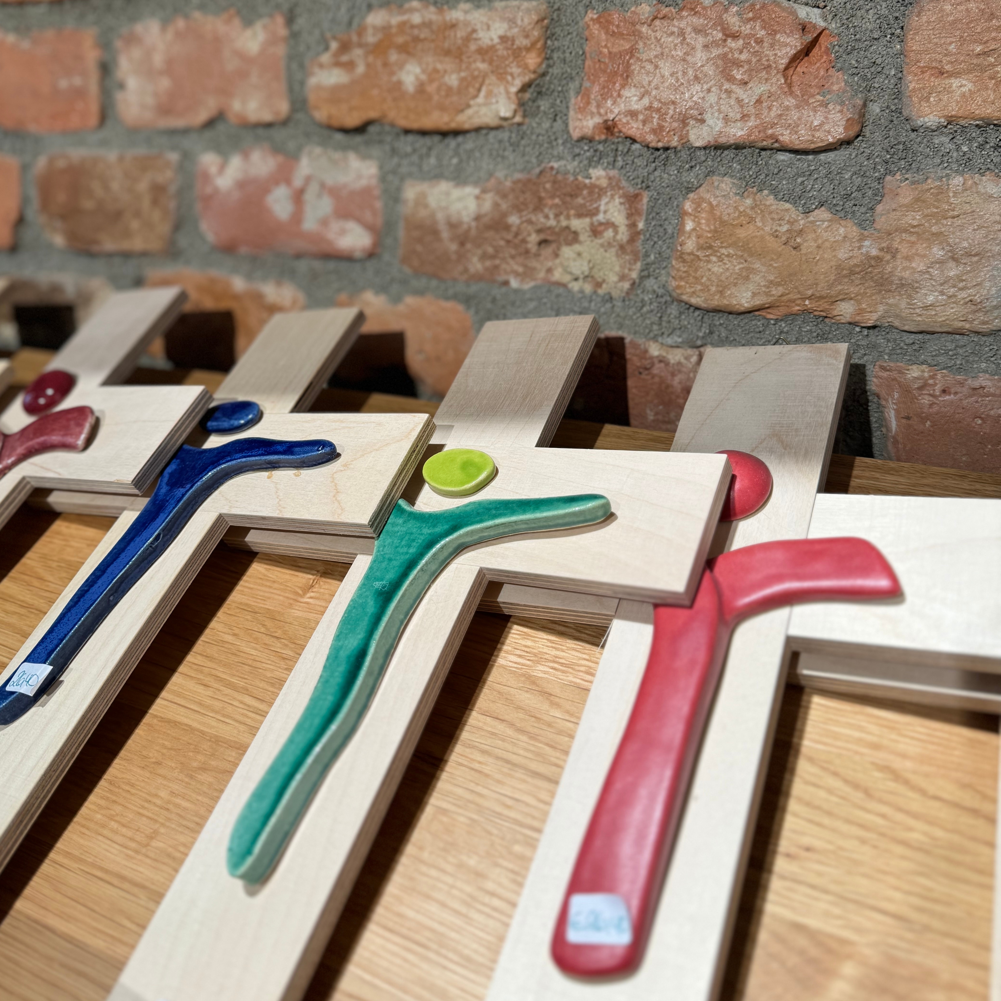 Holzkreuze mit minimalistisch designten Jesus in unterschiedlichen Farben.   