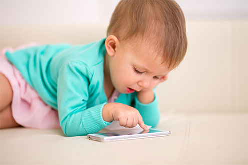 Das Bild zeigt ein Kleinkind beim Spielen mit dem Smartphone
