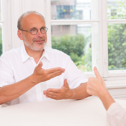 Das Foto zeigt Prof. Johannes Fellinger, der gerade gebärdet