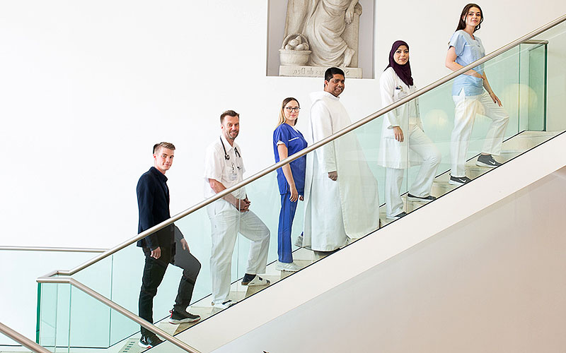 Das Bild zeigt Mitarbeiterinnen und Mitarbeiter auf einer Treppe.