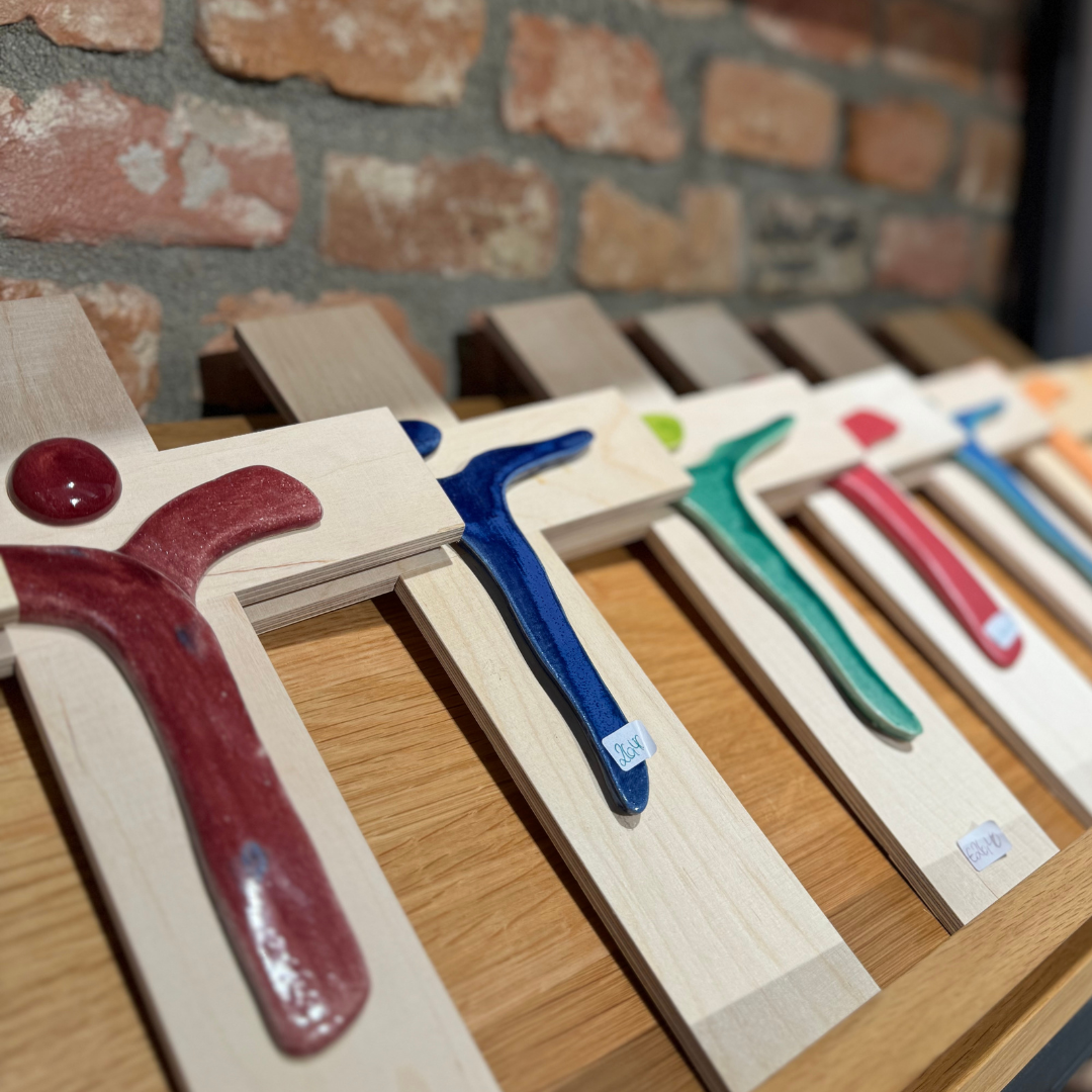 Holzkreuze mit minimalistisch designten Jesus in unterschiedlichen Farben.   