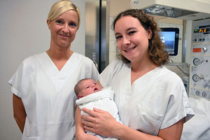 v.l.n.r DGKP Nicole Dörfler und Hebamme Tanja Gruber, BSc mit dem 500. Baby im Arm 