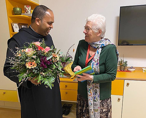 Das Bild zeigt Frater Saji Mullankuzhy, Provinzial der Österreichischen Ordensprovinz, wie er Frau Maria Wachtler zum Geburtstag gratuliert.