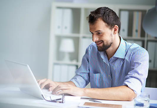 Das Bild zeigt einen Mann vorm Laptop.