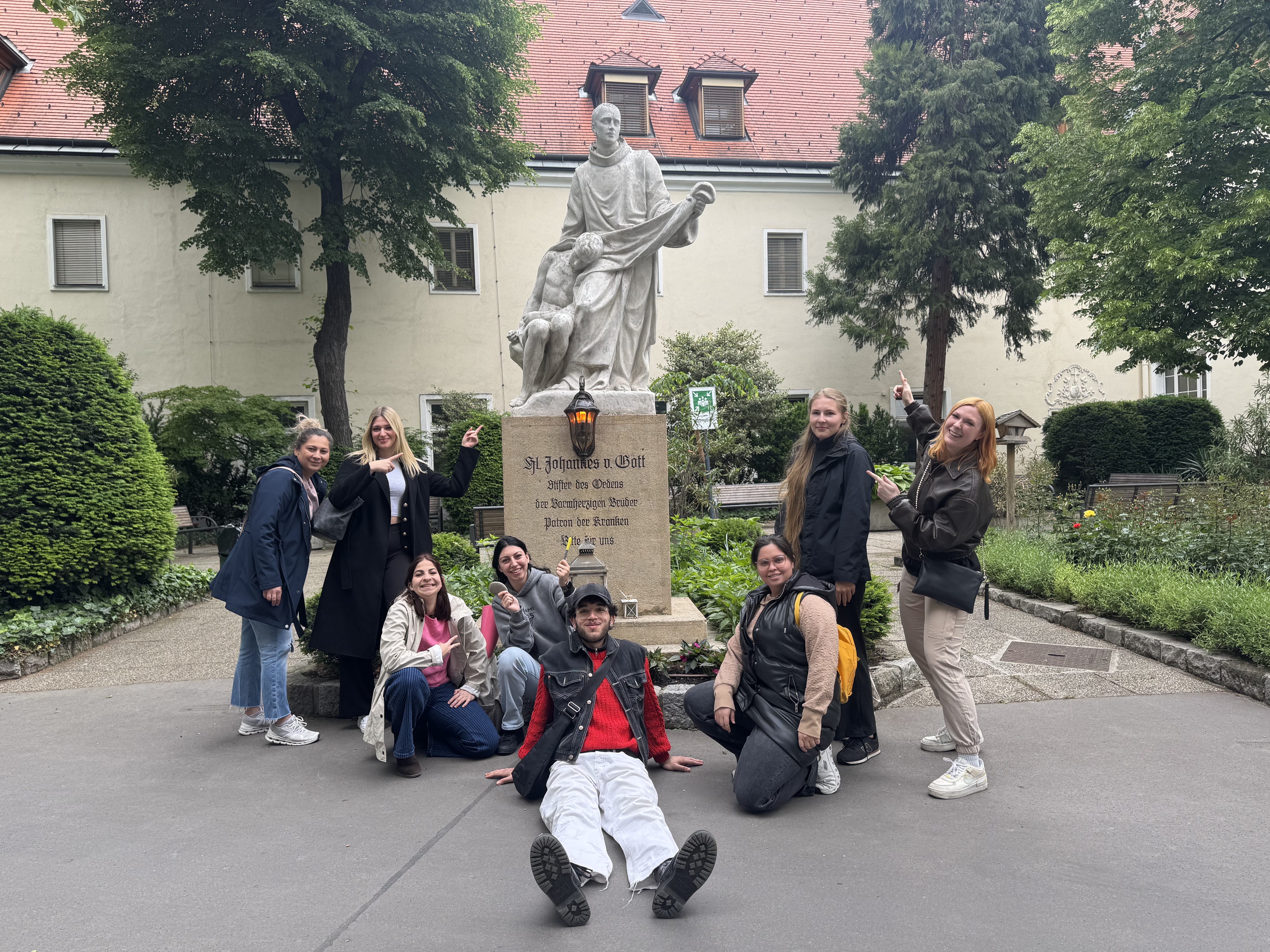 Ein Gruppenfoto vor der Johannes von Gott Statue