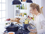 Das Bild zeigt eine Frau beim Kochen.