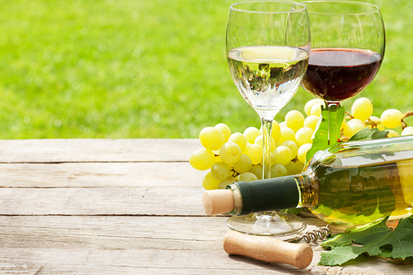 Weiß- und Rotweingläser, Weinflasche und weiße Trauben auf Holztisch / © clipdealer.com Weiß- und Rotweingläser, Weinflasche und weiße Trauben auf Holztisch