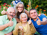 Happy, contented family showing thumbsup for the quality of the residential care of grandmother.