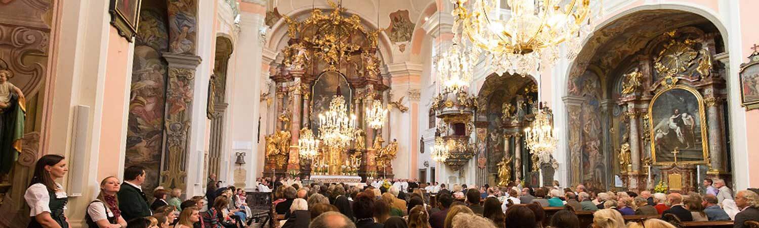 Das Bild zeigt den Innenraum einer Kirche und Gottesdienstbesucher.