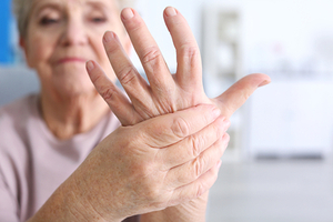 Elderly woman suffering from pain in hand, closeup�