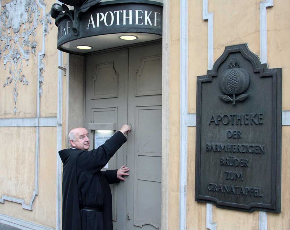 Das Bild zeigt Frater Matthias vor der Apotheke in Graz.